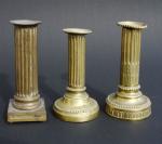 Trois FLAMBEAUX en bronze. Pieds quadrangulaires pour deux et circulaires...