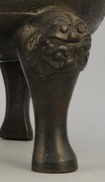 DING tripode en bronze à patine brune, à décor de...